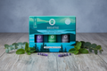 Coffret Breathe huiles essentielles posé sur fond bois avec eucalyptus et menthe